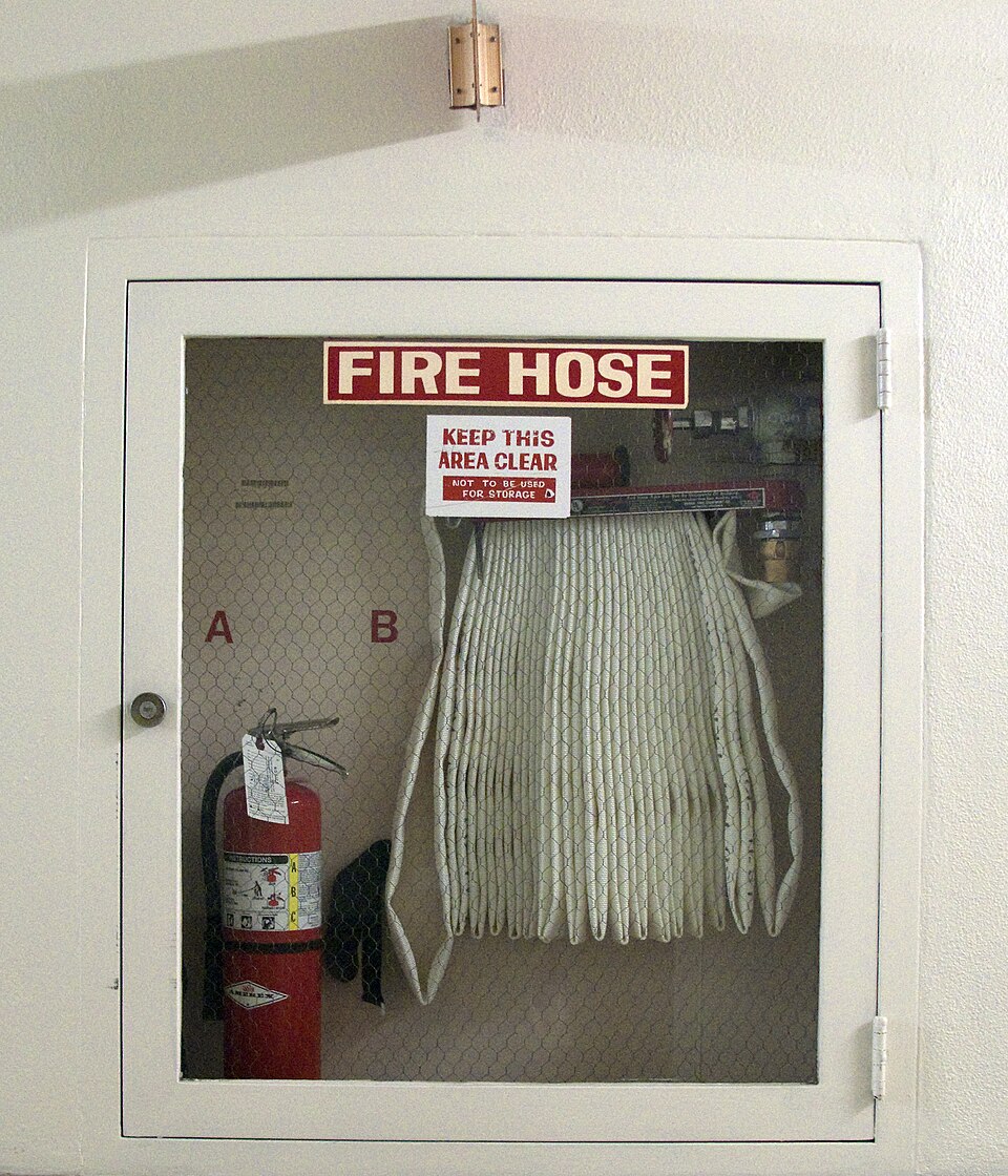 Fire hose cabinet with hose pipe ready for emergency use